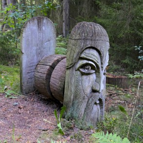 Wooden sculpture with a carved face in the forest by the Paplatelė cognitive trail Wooden sculpture with a carved face in the forest by the Paplatelė cognitive trail