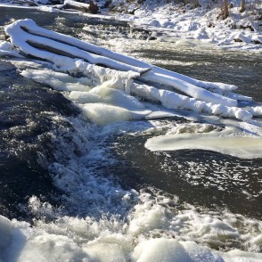 Abava Rumba waterfall in winter close-up with ice sheets and swirling current Abava Rumba waterfall in winter close-up with ice sheets and swirling current