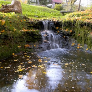 Rumbiņas ūdenskritums rudenī ar kritušām lapām un sūnainu nogāzi Rumbiņas ūdenskritums rudenī ar kritušām lapām un sūnainu nogāzi