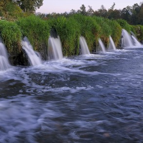 Ventas rumba ar vienmērīgām ūdens straumēm pie zālainā krasta Ventas rumba ar vienmērīgām ūdens straumēm pie zālainā krasta