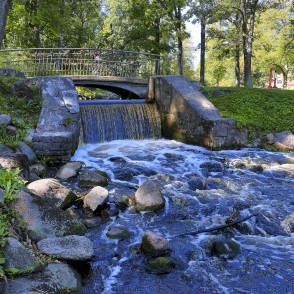Small Bridge over the Mārupīte Stream in Arkādija Park with a Weir Small Bridge over the Mārupīte Stream in Arkādija Park with a Weir