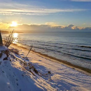Saulriets virs sniegotas piekrastes pie Jūrkalnes stāvkrasta Saulriets virs sniegotas piekrastes pie Jūrkalnes stāvkrasta