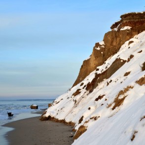 Sniegots Jūrkalnes stāvkrasts pie jūras ar smilšu pludmali Sniegots Jūrkalnes stāvkrasts pie jūras ar smilšu pludmali