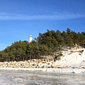 Užava lighthouse against a snowy dune in winter Užava lighthouse against a snowy dune in winter