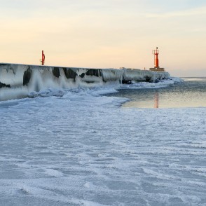 Pavilosta pier in winter with icicles and lighthouse Pavilosta pier in winter with icicles and lighthouse