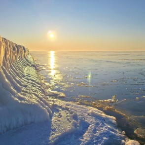 Saules atspulgs aizsalušajā jūrā pie Papes koka steķiem Saules atspulgs aizsalušajā jūrā pie Papes koka steķiem