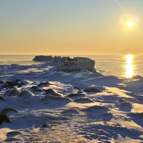 Ziemas saulriets virs sniegotās piekrastes un Papes steķiem Ziemas saulriets virs sniegotās piekrastes un Papes steķiem