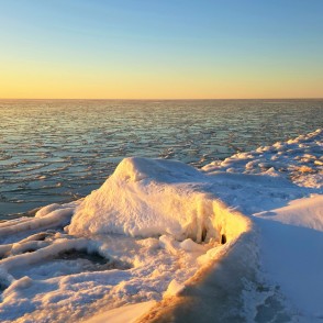 Saulrieta gaisma uz ledus vaļņiem un aizsalušas jūras Papes pludmalē Saulrieta gaisma uz ledus vaļņiem un aizsalušas jūras Papes pludmalē