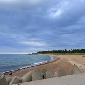 Beach near the Liepāja Northern Breakwater under grey clouded skies Beach near the Liepāja Northern Breakwater under grey clouded skies