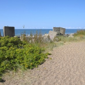 Smilšains ceļš gar piekrasti ar betona blokiem pie jūras Smilšains ceļš gar piekrasti ar betona blokiem pie jūras