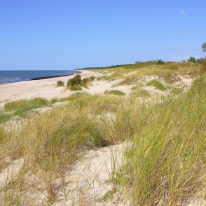 Plaša smilšu pludmale Jūrmalciemā ar kāpām un zaļu veģetāciju Plaša smilšu pludmale Jūrmalciemā ar kāpām un zaļu veģetāciju