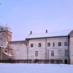 Dundagas pils ziemas vakarā ar torni, vārtiem un sniegotu pagalmu Dundagas pils ziemas vakarā ar torni, vārtiem un sniegotu pagalmu