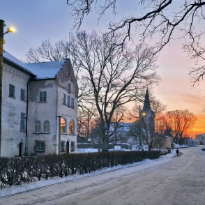 Ziemas iela pie Dundagas pils saulrietā ar baznīcas torni tālumā Ziemas iela pie Dundagas pils saulrietā ar baznīcas torni tālumā
