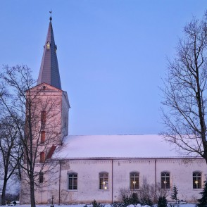 Dundagas luterāņu baznīca ziemā ar sniegotu jumtu un izgaismotiem logiem Dundagas luterāņu baznīca ziemā ar sniegotu jumtu un izgaismotiem logiem