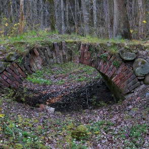 Arkveida tiltiņš uz baronu kapiem Ugāles pilskalnā Arkveida tiltiņš uz baronu kapiem Ugāles pilskalnā