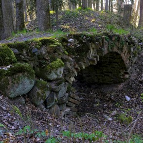 Arkveida tiltiņš uz baronu kapiem Ugāles pilskalnā Arkveida tiltiņš uz baronu kapiem Ugāles pilskalnā