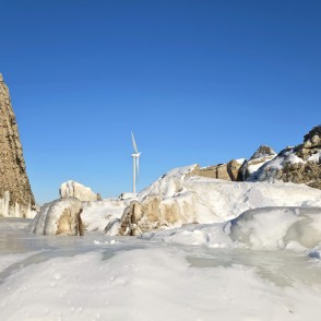 Vertikālas betona drupas un vēja ģenerators ziemas ainavā Vertikālas betona drupas un vēja ģenerators ziemas ainavā