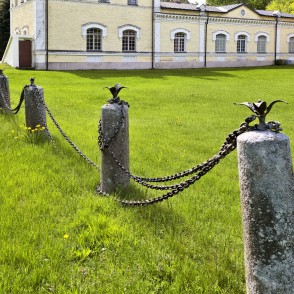 Vēsturiskie akmens stabi ar ķēdēm Doles muižas pils zālienā Vēsturiskie akmens stabi ar ķēdēm Doles muižas pils zālienā