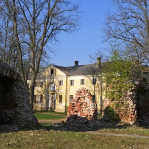 Skats caur Elejas muižas drupām uz muižas teātra māju jeb klēti Skats caur Elejas muižas drupām uz muižas teātra māju jeb klēti