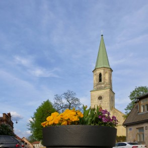 Skats uz Kuldīgas luterāņu baznīcu caur puķēm Skats uz Kuldīgas luterāņu baznīcu caur puķēm