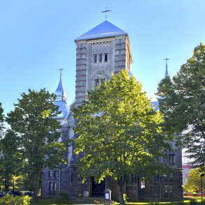 View of Liepaja Luther Church through tree foliage in a well-kept park View of Liepaja Luther Church through tree foliage in a well-kept park