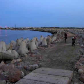 Evening view of Ventspils Southern Pier with cyclists Evening view of Ventspils Southern Pier with cyclists
