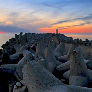 Sunset at Ventspils Southern Pier with lighthouse and concrete wave breakers Sunset at Ventspils Southern Pier with lighthouse and concrete wave breakers