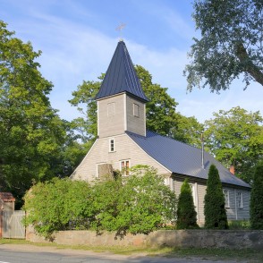 Engures luterāņu baznīca sānskatā ar koka sienām un torni koku ieskautā ainavā Engures luterāņu baznīca sānskatā ar koka sienām un torni koku ieskautā ainavā