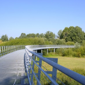 Pedestrian bridge over the Bārta in a green landscape at Vaclava Inta Stone Park Pedestrian bridge over the Bārta in a green landscape at Vaclava Inta Stone Park