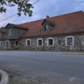 Sedas ūdensdzirnavu akmens ēka ar sarkanu dakstiņu jumtu vakara krēslā Sedas ūdensdzirnavu akmens ēka ar sarkanu dakstiņu jumtu vakara krēslā