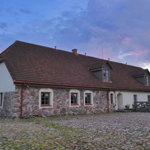 Sedas ūdensdzirnavu ēka ar akmens sienām un sarkanu jumtu bruģētā pagalmā Sedas ūdensdzirnavu ēka ar akmens sienām un sarkanu jumtu bruģētā pagalmā