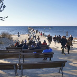 Palanga Sea Pier promenade with people and benches by the sea Palanga Sea Pier promenade with people and benches by the sea