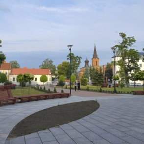 Marijampoles pilsētas skvērs ar baznīcas torni tālumā Marijampoles pilsētas skvērs ar baznīcas torni tālumā