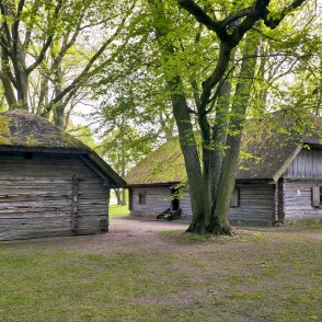 Ancient wooden outbuildings and a residential house in the yard of the Daugava Museum Ancient wooden outbuildings and a residential house in the yard of the Daugava Museum