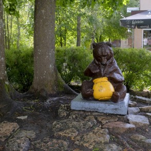 Skulptūru ar lācēnu, kurš tukšo medus podu Skulptūru ar lācēnu, kurš tukšo medus podu
