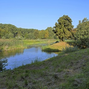 Bend of the Bārta River with tree-lined banks in a Skuodas city park Bend of the Bārta River with tree-lined banks in a Skuodas city park