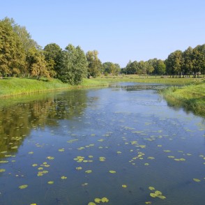 Wide stretch of the Bārta River with lawns and trees in a Skuodas city park Wide stretch of the Bārta River with lawns and trees in a Skuodas city park