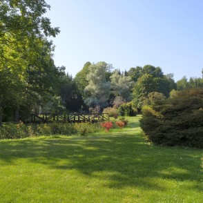 Green landscape with a wooden bridge in Vaclovas Intas stone park Green landscape with a wooden bridge in Vaclovas Intas stone park