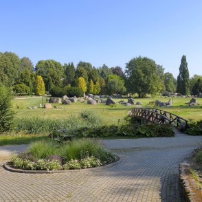 Scenic stone park with pedestrian bridge and landscaped greenery Scenic stone park with pedestrian bridge and landscaped greenery
