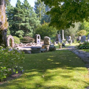 Stone garden with arch gateways and a path under large trees Stone garden with arch gateways and a path under large trees