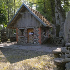 Stone cottage in a garden with cobblestone courtyard and large boulders Stone cottage in a garden with cobblestone courtyard and large boulders
