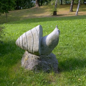 Stone snail sculpture on a boulder base in Salantai City Park Stone snail sculpture on a boulder base in Salantai City Park