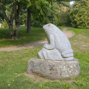 Stone frog sculpture beside a walking path in Salantai City Park Stone frog sculpture beside a walking path in Salantai City Park