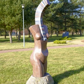 Abstrakta akmens skulptūra cilvēka torsā zālienā pie parka celiņa Abstrakta akmens skulptūra cilvēka torsā zālienā pie parka celiņa