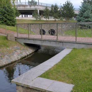 Gājēju tilts pār akmens kanālu Marijampoles Dzejas parkā Gājēju tilts pār akmens kanālu Marijampoles Dzejas parkā