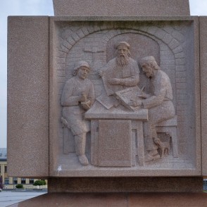 Bareljefs ar viduslaiku grāmatas iespiešanas ainu uz pieminekļa Marijampolē Bareljefs ar viduslaiku grāmatas iespiešanas ainu uz pieminekļa Marijampolē