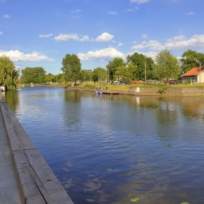 Danes upes skats no promenādes ar koka krastmalu un koku ieskautiem krastiem Danes upes skats no promenādes ar koka krastmalu un koku ieskautiem krastiem