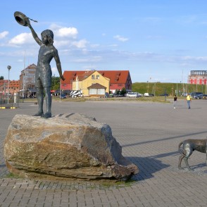 Skulptūra Bērnības sapnis un pilsētas fons Klaipēdas krastmalā Skulptūra Bērnības sapnis un pilsētas fons Klaipēdas krastmalā